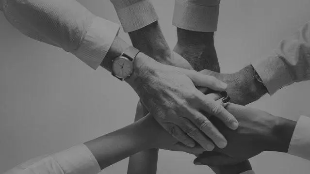 Hands joined together in the middle of a circle